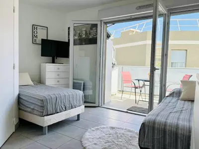 a bedroom with a bed and a sliding glass door at Cosy Apartment Vauban in Nice
