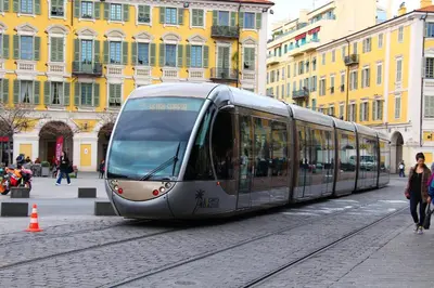 a silver tram on a city street with buildings at Cosy Apartment Vauban in Nice