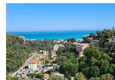 a town on a hill with the ocean in the background at Magnifique vue mer - Piscine -Tennis in Nice