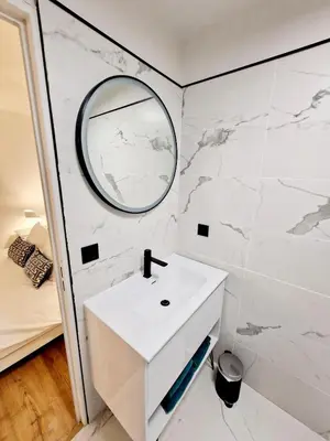 a bathroom with a white sink and a mirror at Magnifique vue mer - Piscine -Tennis in Nice