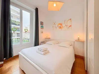 a white bedroom with a white bed and a window at Charmant 2P près du Negresco et de la plage - 3pers in Nice