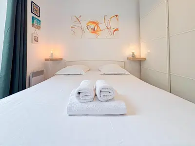 a bedroom with a white bed with towels on it at Charmant 2P près du Negresco et de la plage - 3pers in Nice