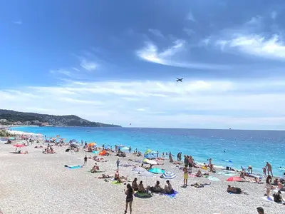 a group of people on a beach with an airplane at Appartement 50m2 proche mer in Nice
