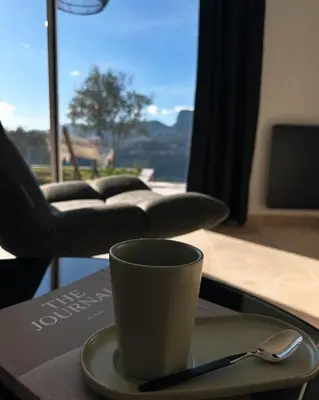 a coffee cup on a plate with a spoon on a table at Maison C in Nice
