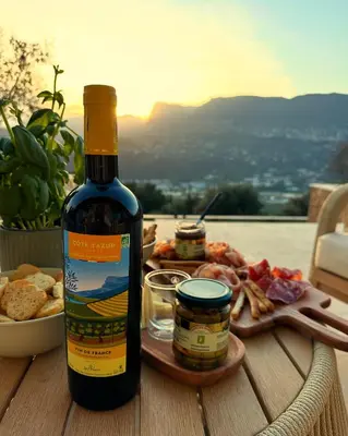 a bottle of wine sitting on a table with a plate of food at Maison C in Nice