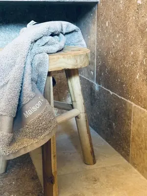a towel sitting on a wooden stool in a bathroom at Maison C in Nice