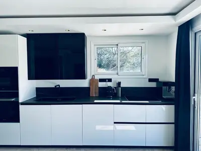 a kitchen with white cabinets and a window at Maison C in Nice