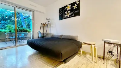 a bedroom with a bed in a room with a table at Le Ciel in Nice