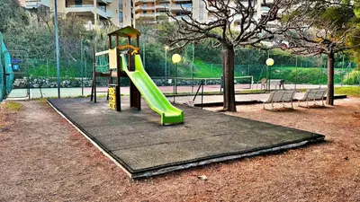 a playground with a green slide in a park at Le Ciel in Nice