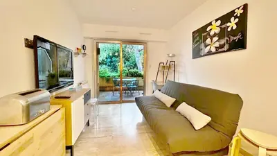 a living room with a couch and a tv at Le Ciel in Nice