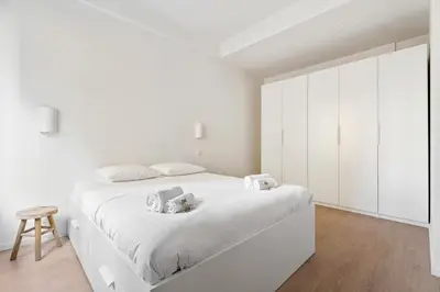 a white bedroom with white cabinets and a white bed at Appartement Ostave - Welkeys in Nice
