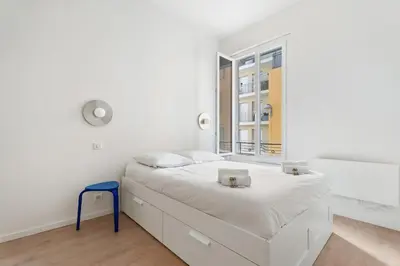 a white bedroom with a bed and a window at Appartement Ostave - Welkeys in Nice