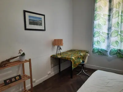 a bedroom with a desk and a window with a curtain at Appartement près des plages in Nice