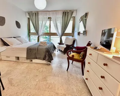 a bedroom with a bed and a television and a chair at A G Cocon Massenet - Grimaldi - Promenade des Angl in Nice