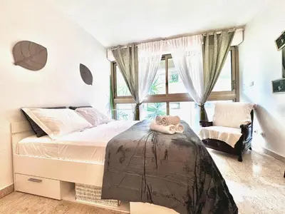 a bedroom with a bed and a chair and a window at A G Cocon Massenet - Grimaldi - Promenade des Angl in Nice