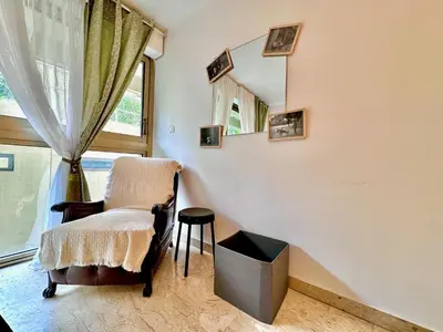 a living room with a chair and a mirror at A G Cocon Massenet - Grimaldi - Promenade des Angl in Nice