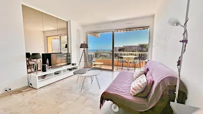 a living room with a couch and a tv and a table at Vista Mare in Nice