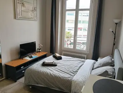 a bedroom with a bed and a desk with a television at Studio central Nice in Nice