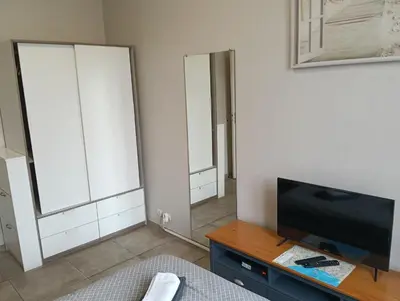 a living room with a tv and two mirrors at Studio central Nice in Nice