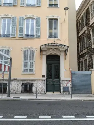 a building with a green door on a city street at Studio central Nice in Nice