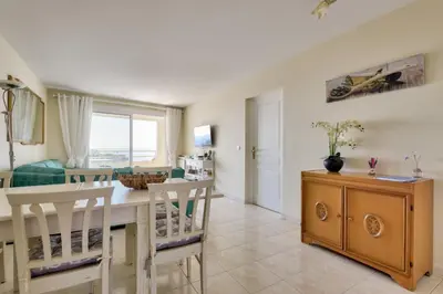 a kitchen and dining room with a table and chairs at T3 avec terrasse vue sur mer à 400m de la plage in Nice