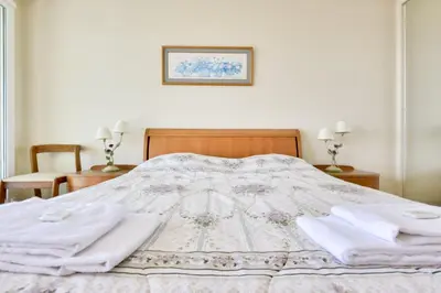 a bed with two white towels on top of it at T3 avec terrasse vue sur mer à 400m de la plage in Nice