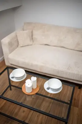 a living room with a couch and a table with plates at Vieux Nice - Dernier étage climatisé in Nice