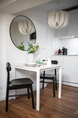 a white dining room table with two chairs and a mirror at Vieux Nice - Dernier étage climatisé in Nice