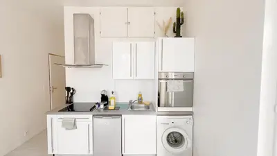 a white kitchen with a sink and a dishwasher at La Bella Niçoise in Nice