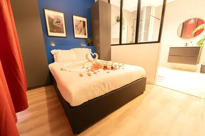 a bedroom with a bed with flowers on it at Nice Centre - Loft - Balnéo 1 in Nice