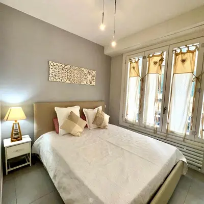 a bedroom with a large white bed with windows at Suite Doulce France FSHH in Nice