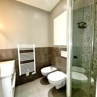 a bathroom with a toilet and a glass shower at Suite Doulce France FSHH in Nice