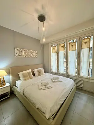 a bedroom with a large white bed and windows at Suite Doulce France FSHH in Nice