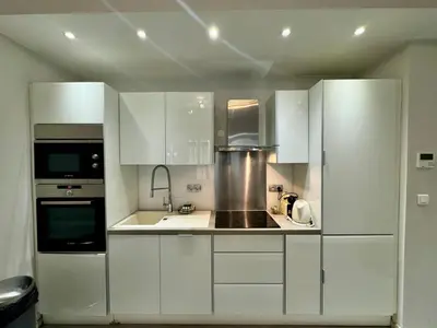 a kitchen with white cabinets and a refrigerator at Suite Doulce France FSHH in Nice