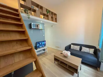 a living room with a blue couch and a staircase at ⁂ Appartement élégant et central à Nice in Nice