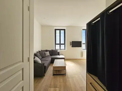 a living room with a couch and a table at Joli studio rénové en centre-ville proche tramway in Nice