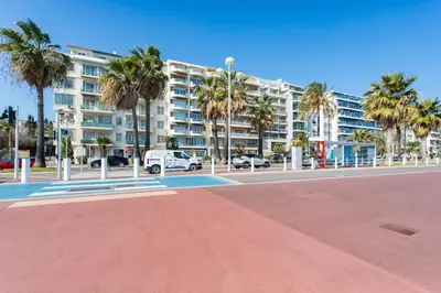 a large apartment building with palm trees in a parking lot at #37 1BDR Bagatelle, Promenade, sea front Balcony & AC in Nice