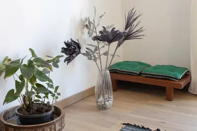 a vase with flowers and plants in a room with a bench at #37 1BDR Bagatelle, Promenade, sea front Balcony & AC in Nice