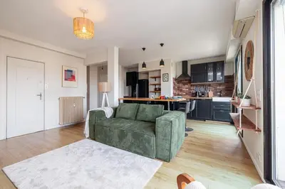 a living room with a green couch and a kitchen at MY CASA - DELFINO - Charming roof terrace apartment w AC in Nice