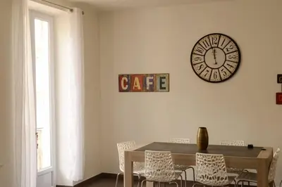 a dining room with a table and a clock on the wall at Hype-Center Balcony 3BR AC Near Tram for6 guests in Nice