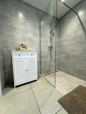 a bathroom with a shower with a glass door at Appartement entre Monaco et Nice Calme et tout équipé in Èze