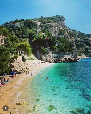 a group of people on a beach in the water at Appartement entre Monaco et Nice Calme et tout équipé in Èze