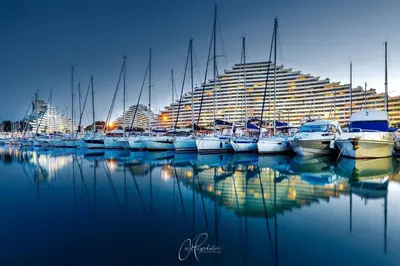a group of boats docked in a harbor with a large building at Villa La Mer new apartment 75 m2 very quiet in Cagnes-sur-Mer