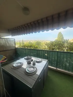 a table with plates of food on a balcony at Apartment near Beach-Airport Open 24h in Saint-Laurent-du-Var