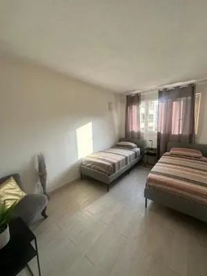 a bedroom with two beds and a couch at Apartment near Beach-Airport Open 24h in Saint-Laurent-du-Var
