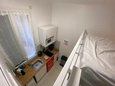 a small bathroom with a sink and a bed at Studio Garibaldi in Nice