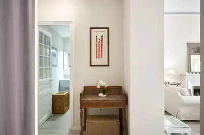 a hallway with a table and a living room at Sunlight Properties - Gisele - Nice hyper central, 1 bedroom with large living room in Nice