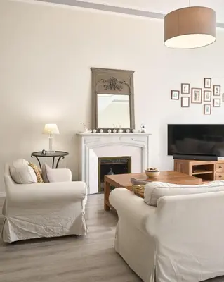 a living room with white furniture and a fireplace at Sunlight Properties - Gisele - Nice hyper central, 1 bedroom with large living room in Nice