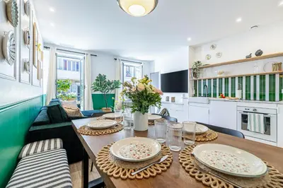 a dining room with a table and a kitchen at NEW! Remodeled & Spacious 4 Bedroom - 3 Bath - Heart of Nice - AC in all rooms - With a large elevator in Nice