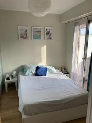 a bedroom with a white bed with a blue pillow at 2P cosy à Nice in Nice
